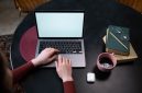 Seorang kreator konten sedang menyusun narasi pribadi di situs web miliknya sembari menikmati suasana tenang di sebuah kedai kopi. Kemudahan pengelolaan platform digital kini memberikan kemerdekaan penuh bagi individu untuk mempublikasikan karya tanpa batasan algoritma media sosial.