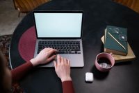 Seorang kreator konten sedang menyusun narasi pribadi di situs web miliknya sembari menikmati suasana tenang di sebuah kedai kopi. Kemudahan pengelolaan platform digital kini memberikan kemerdekaan penuh bagi individu untuk mempublikasikan karya tanpa batasan algoritma media sosial.